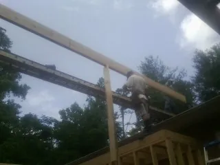 Carpenter setting a ridge beam over a new addition frame — Ice Dam Removal by Roofing Brothers in Hendersonville