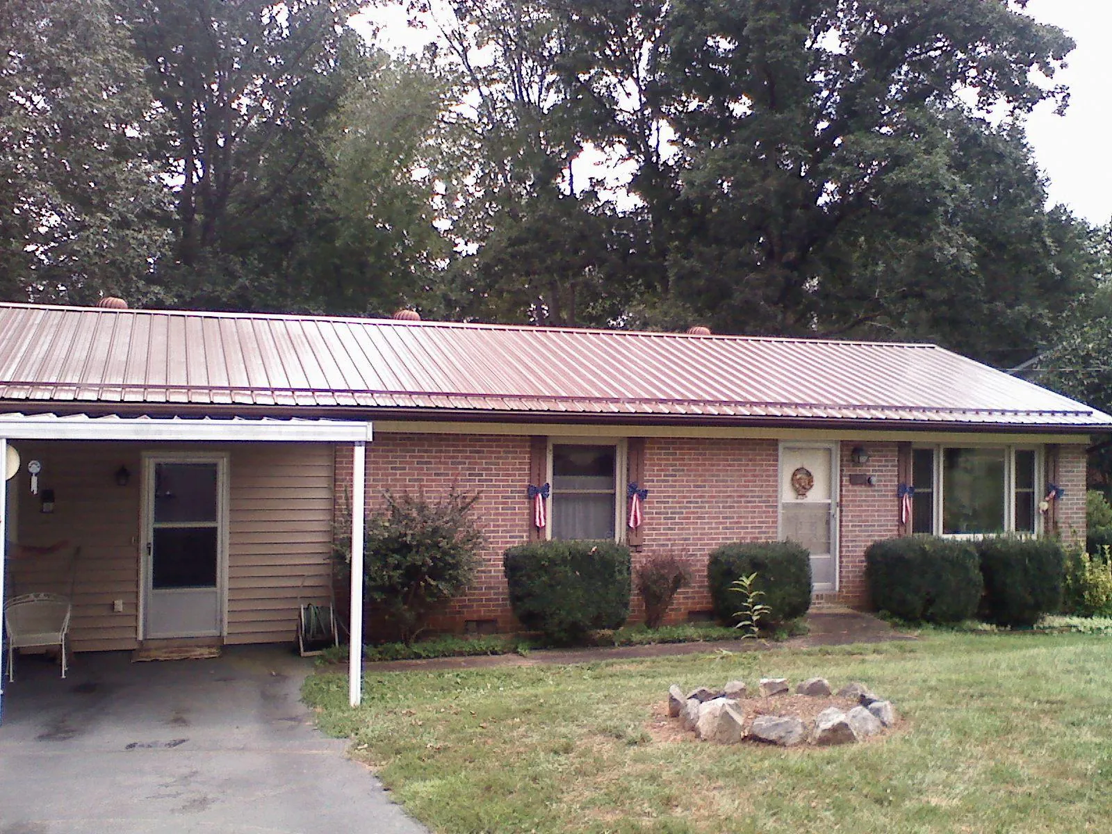 Bronze metal roof and carport on a brick ranch home — Roof Repair work by our crew in Hendersonville