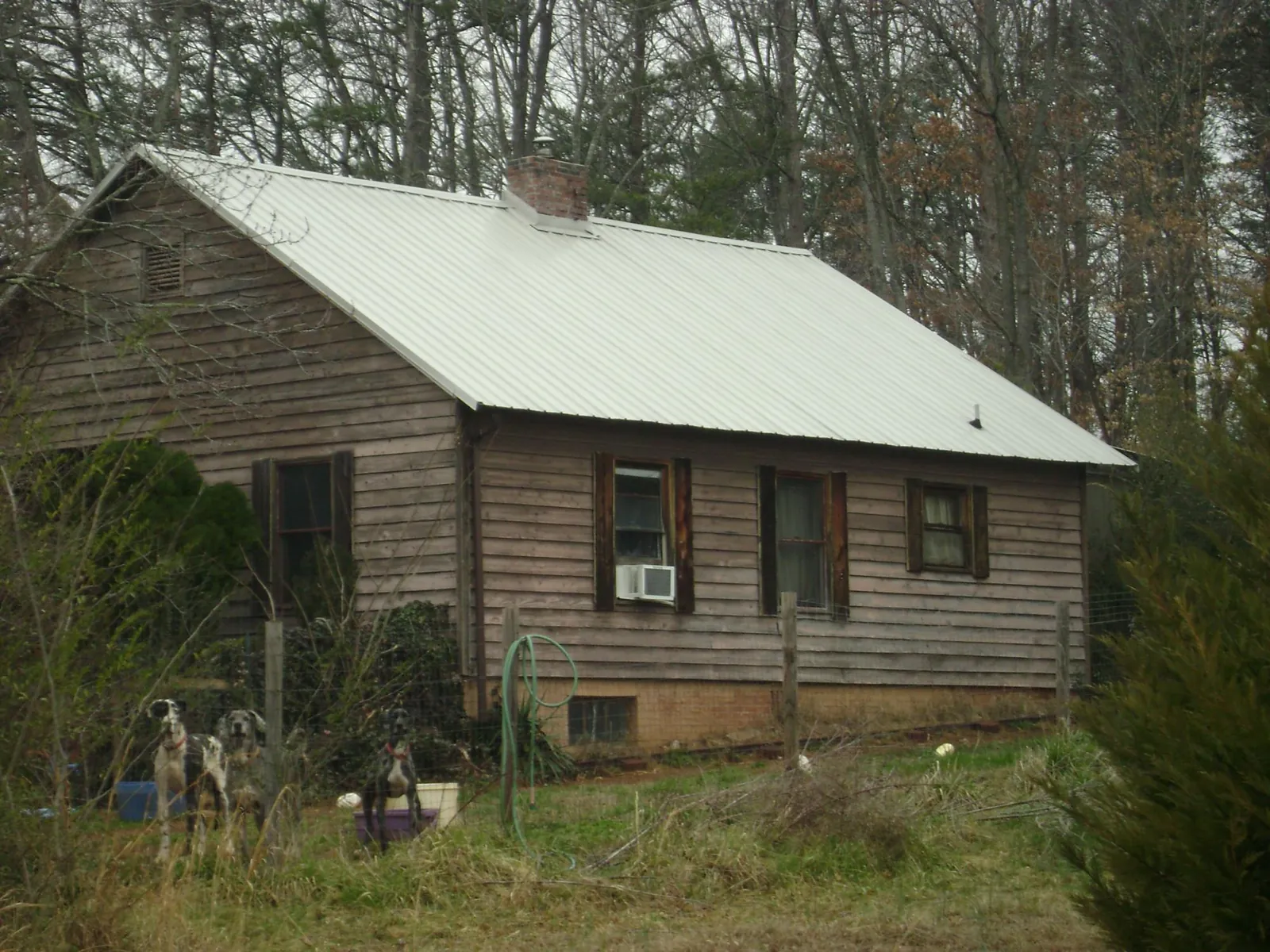White metal roof on an old wood sided farmhouse, from a Metal Roof Installation job in Hendersonville